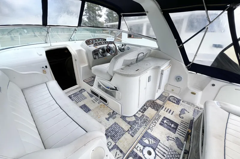 Slide: The Image of 2000 Rinker Fiesta Vee 330 boat interior with white seating and patterned carpet. - 8