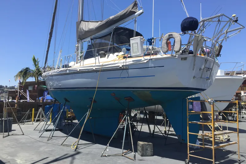 Slide: The Image of 1985 Passport 470 Center Cockpit sailboat docked at marina, featuring sleek design and equipment. - 1