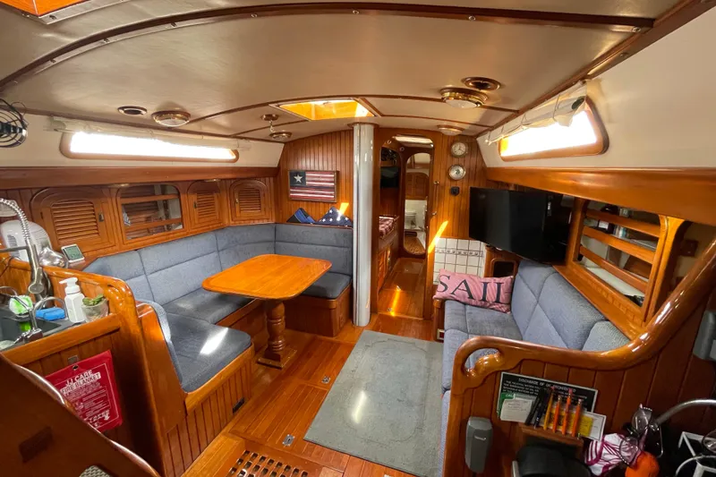 Slide: The Image of Interior of 1985 Passport 470 Center Cockpit sailboat with cozy seating and wooden finishes. - 13
