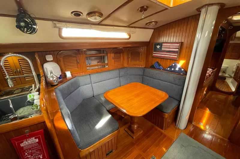 Slide: The Image of Cozy interior of 1985 Passport 470 Center Cockpit with wooden dining area and nautical decor. - 16