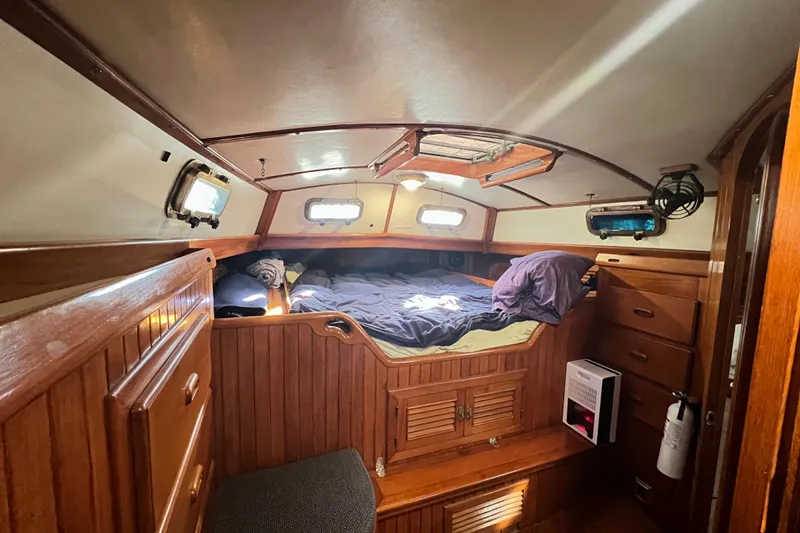 Slide: The Image of Cozy cabin interior of 1985 Passport 470 Center Cockpit sailboat with plaid bedding. - 19