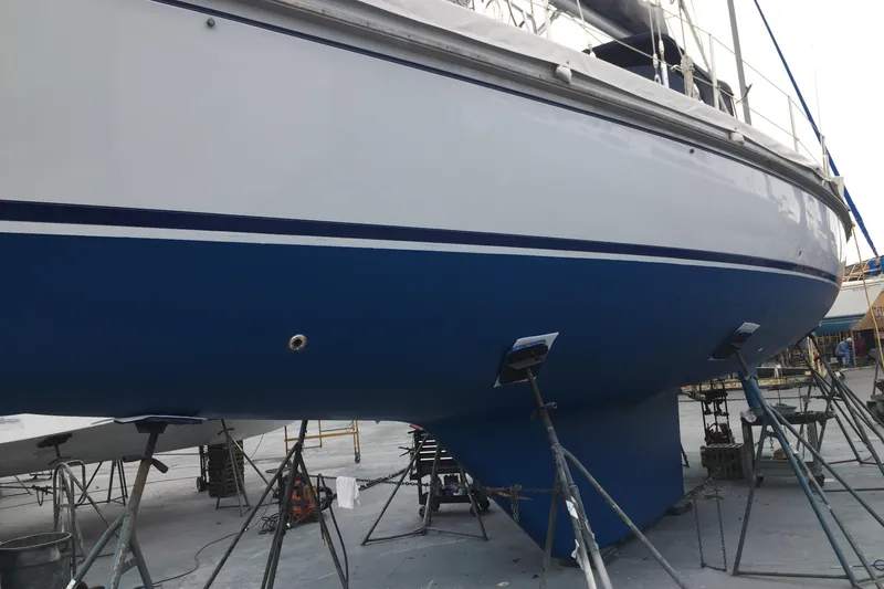 Slide: The Image of 1985 Passport 470 Center Cockpit sailboat docked at marina, surrounded by other boats. - 2