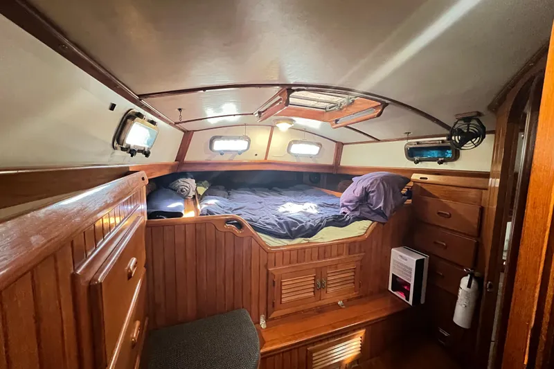 Slide: The Image of 1985 Passport 470 Center Cockpit bathroom with shower, toilet, and wooden accents. - 20