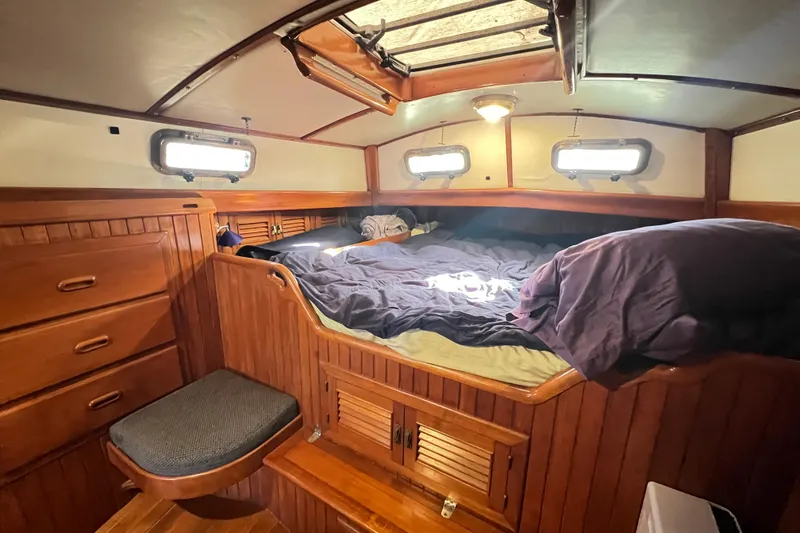 Slide: The Image of Cozy cabin interior of 1985 Passport 470 Center Cockpit sailboat with wooden furnishings. - 21