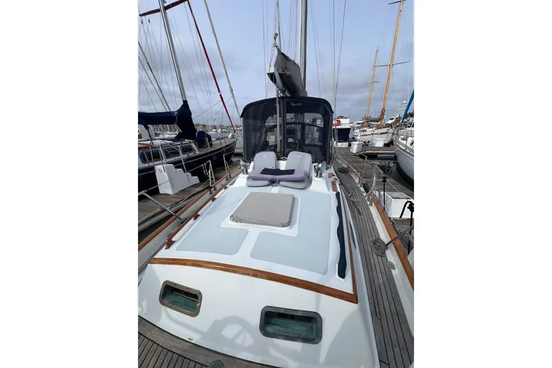 Slide: The Image of 1985 Passport 470 Center Cockpit sailboat docked, featuring spacious deck and sleek design. - 27