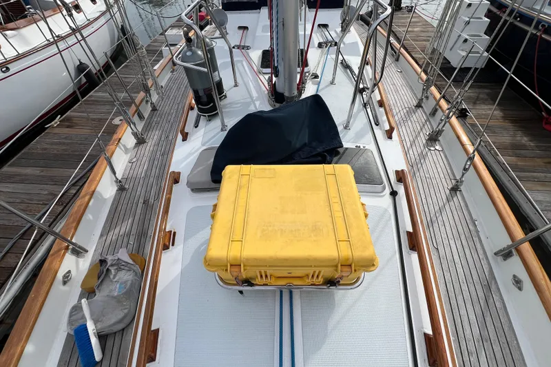 Slide: The Image of 1985 Passport 470 Center Cockpit sailboat deck with yellow storage case and cleaning supplies. - 34