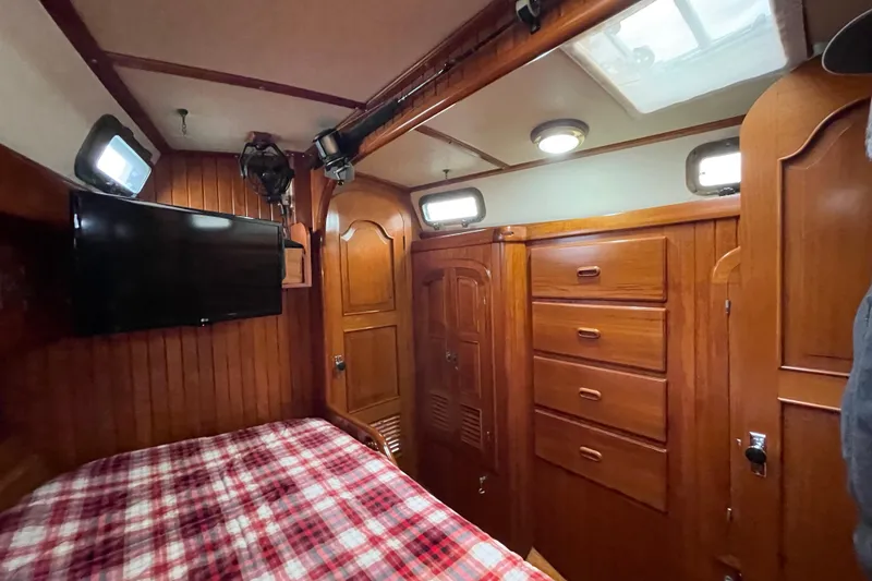 Slide: The Image of 1985 Passport 470 Center Cockpit sailboat on stands, showcasing blue and white hull. - 4