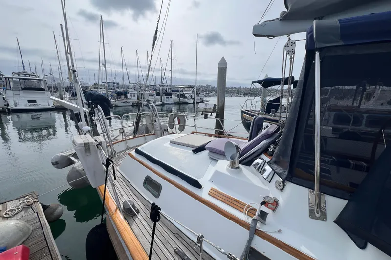 Slide: The Image of 1985 Passport 470 Center Cockpit sailboat docked in a marina with other boats. - 45