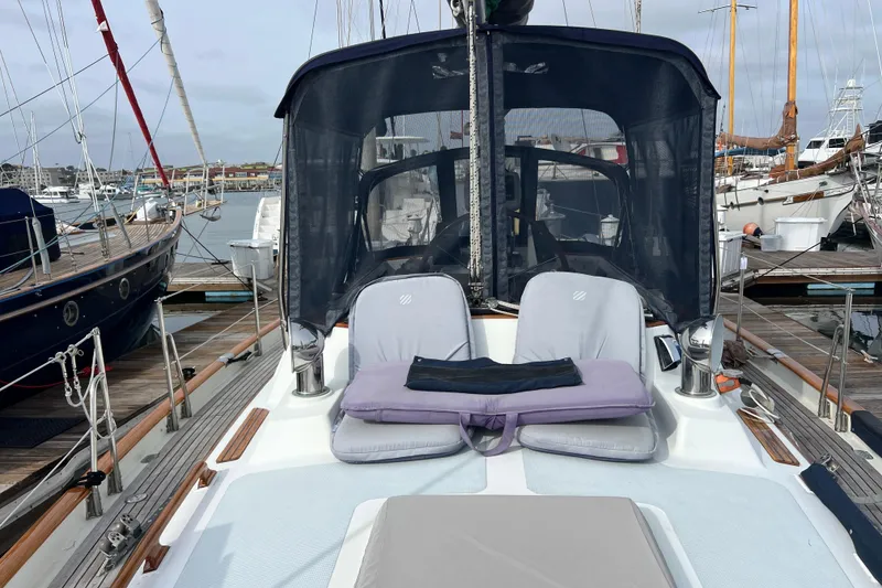 Slide: The Image of 1985 Passport 470 Center Cockpit sailboat docked, featuring comfortable seating and protective canopy. - 51