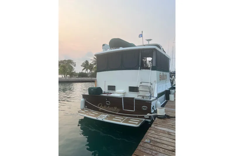 The Image of 1989 Jefferson Marquessa 52 yacht docked at sunset, featuring an extended deckhouse. - 0