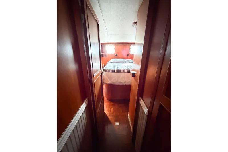 Slide: The Image of Narrow hallway leading to a cozy bedroom in a 1989 Jefferson Marquessa 52 yacht. - 100