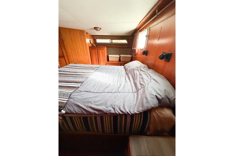 Slide: The Image of Cozy bedroom in 1989 Jefferson Marquessa 52 yacht with wood paneling and striped bedding. - 102