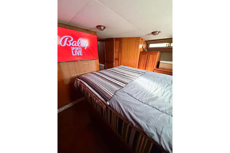 Slide: The Image of Cozy bedroom in 1989 Jefferson Marquessa 52 yacht with TV and striped bedding. - 103
