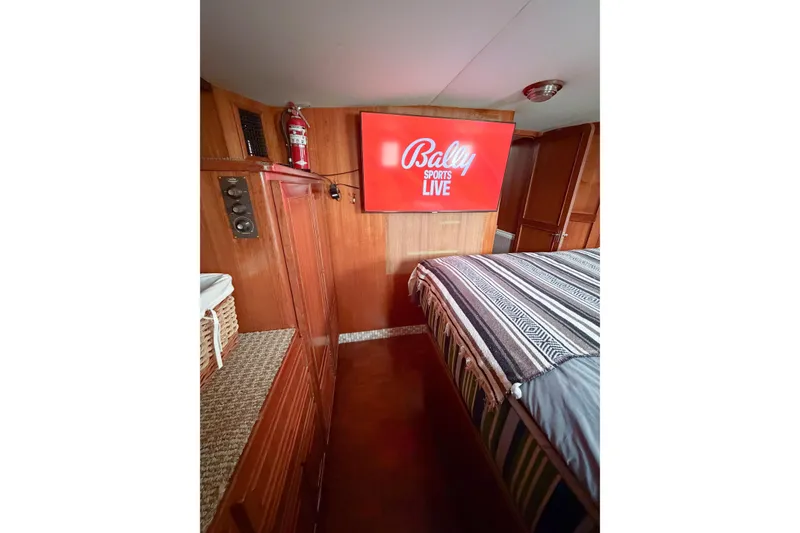 Slide: The Image of Cozy cabin interior of 1989 Jefferson Marquessa 52 with TV and striped bedding. - 104