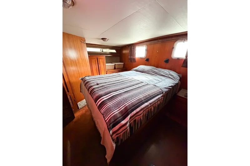 Slide: The Image of Cozy bedroom in 1989 Jefferson Marquessa 52 yacht with wooden interior and striped bedding. - 105
