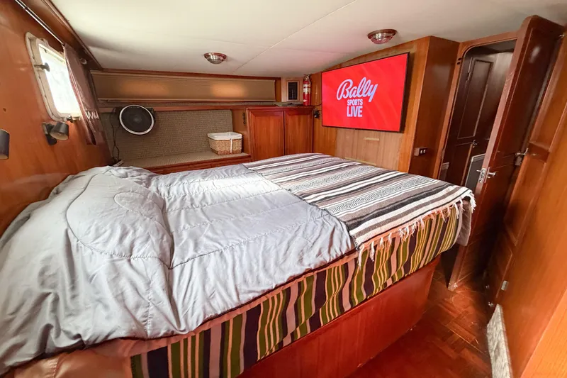 Slide: The Image of Cozy bedroom in 1989 Jefferson Marquessa 52 yacht with TV and striped bedding. - 106