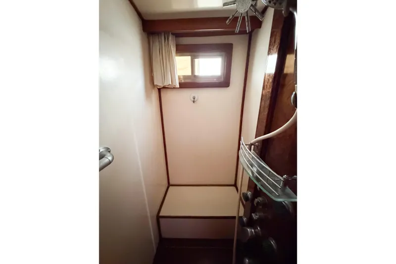 Slide: The Image of Shower area in 1989 Jefferson Marquessa 52 Extended Deckhouse yacht, featuring wooden accents and a window. - 109