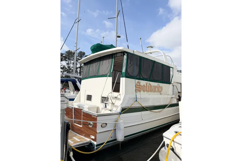 Slide: The Image of 1989 Jefferson Marquessa 52 yacht docked, featuring extended deckhouse and green accents. - 12