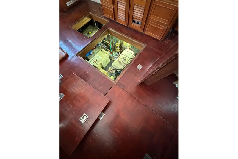 Slide: The Image of Engine room access on 1989 Jefferson Marquessa 52 Extended Deckhouse yacht, featuring wooden flooring. - 123