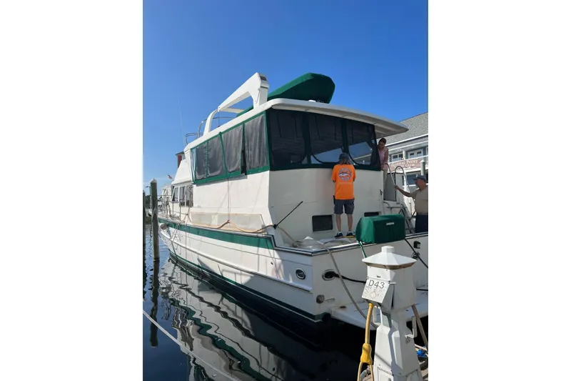Slide: The Image of 1989 Jefferson Marquessa 52 Extended Deckhouse yacht docked at marina with people onboard. - 125