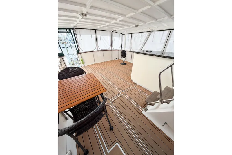 Slide: The Image of Spacious deck of 1989 Jefferson Marquessa 52 yacht with wooden flooring and seating area. - 17