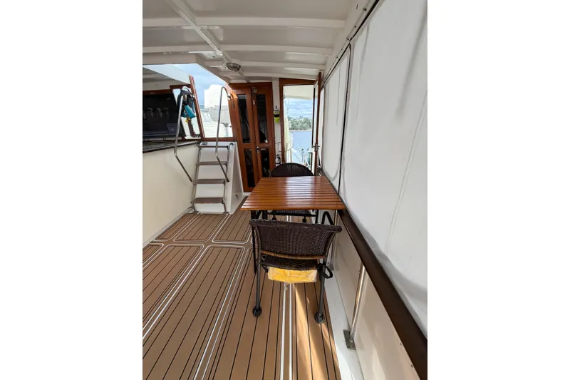 Slide: The Image of 1989 Jefferson Marquessa 52 yacht deck with table, chairs, and ladder. - 21