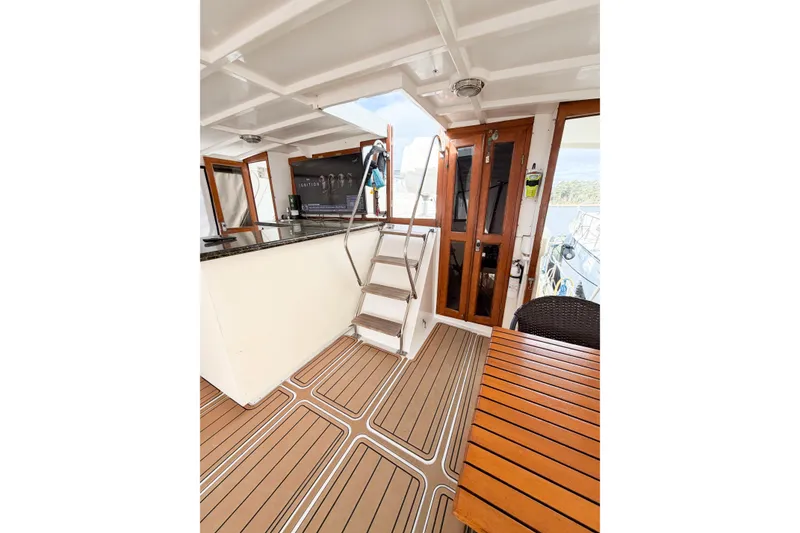 Slide: The Image of 1989 Jefferson Marquessa 52 yacht interior with wooden flooring, stairs, and seating area. - 22