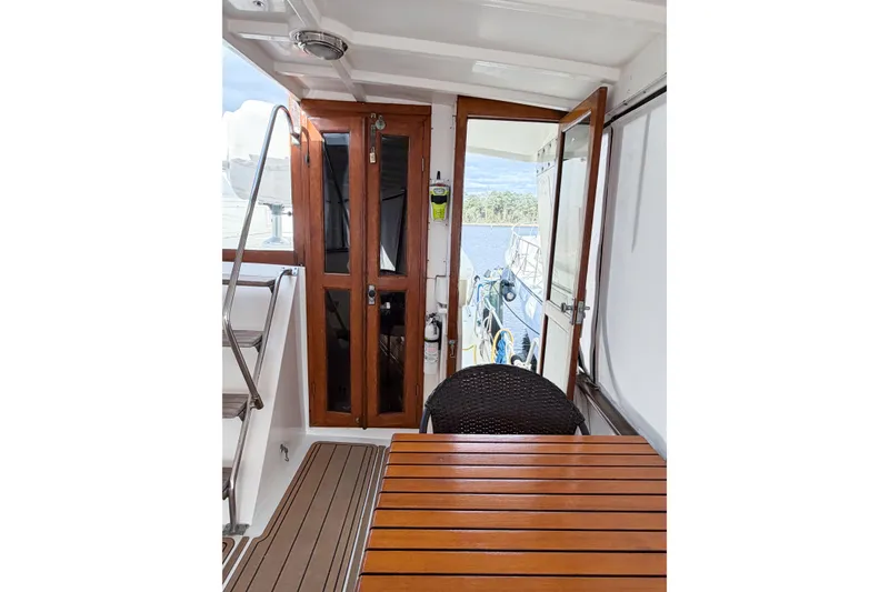 Slide: The Image of Interior view of 1989 Jefferson Marquessa 52 yacht with wooden table and open door to deck. - 23