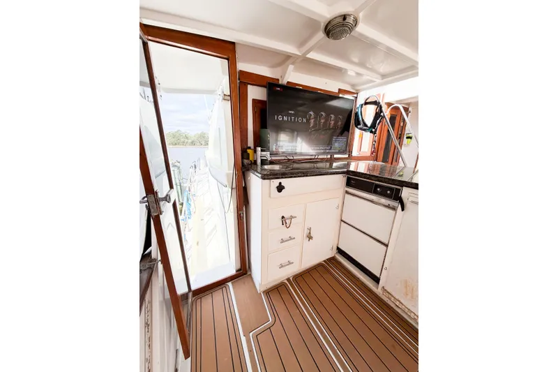 Slide: The Image of Interior of 1989 Jefferson Marquessa 52 yacht with TV, cabinets, and wooden flooring. - 24