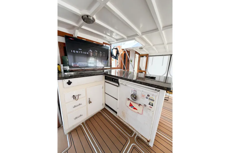 Slide: The Image of 1989 Jefferson Marquessa 52 yacht interior with TV, cabinets, and wood flooring. - 26