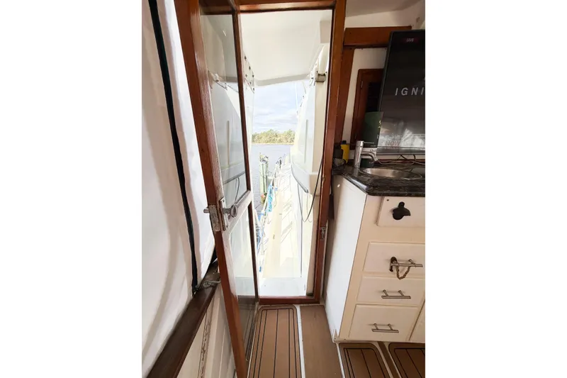Slide: The Image of Interior view of 1989 Jefferson Marquessa 52 yacht, featuring a wooden door and kitchenette. - 27