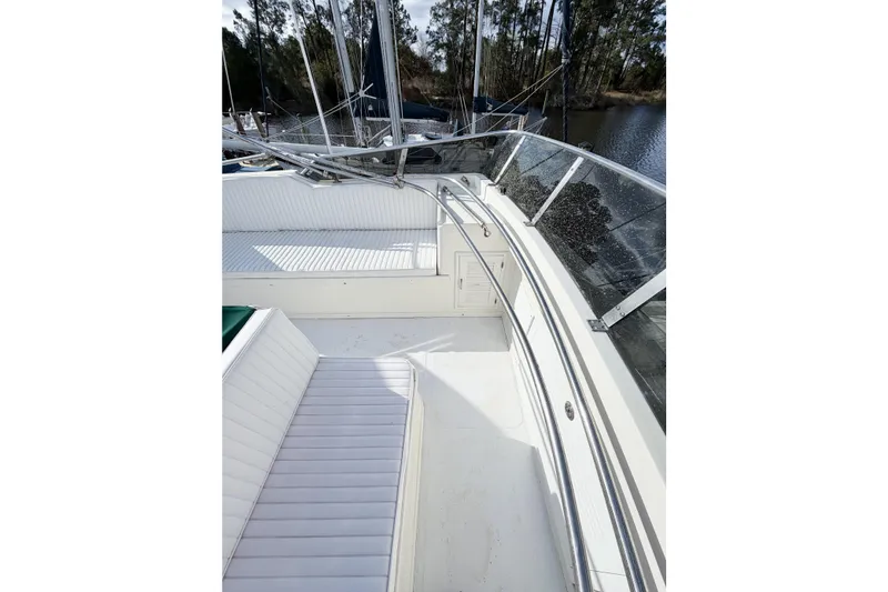 Slide: The Image of 1989 Jefferson Marquessa 52 yacht deck with white seating and railing, docked by trees. - 30