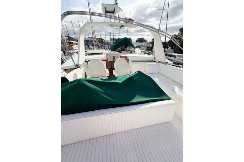Slide: The Image of 1989 Jefferson Marquessa 52 yacht deck with seating and green covers in a marina. - 32