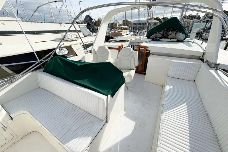 Slide: The Image of 1989 Jefferson Marquessa 52 yacht deck with white seating and green covers in marina. - 34