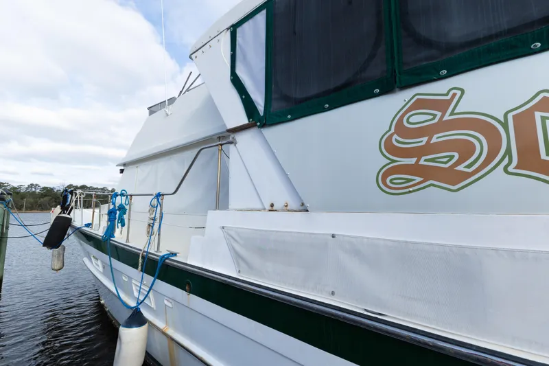 Slide: The Image of 1989 Jefferson Marquessa 52 Extended Deckhouse yacht docked, featuring elegant design and detailed lettering. - 4