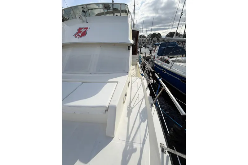 Slide: The Image of 1989 Jefferson Marquessa 52 yacht docked, showcasing extended deckhouse and sleek design. - 40