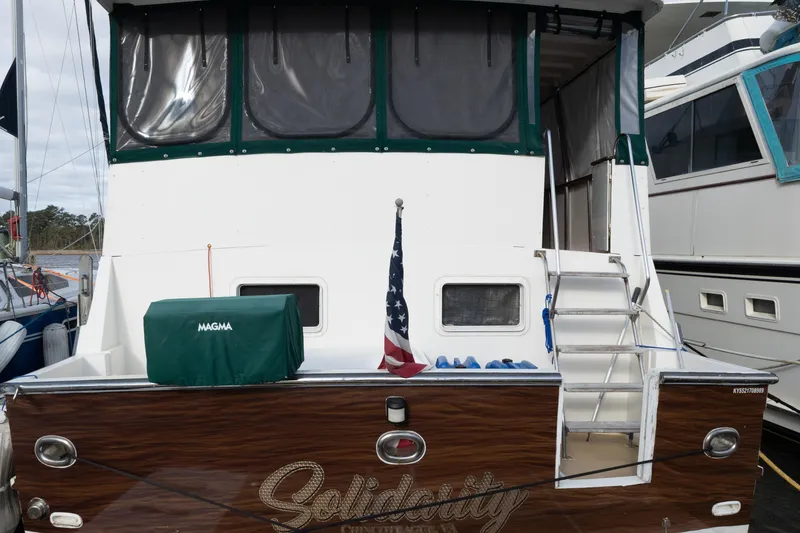 Slide: The Image of 1989 Jefferson Marquessa 52 yacht with American flag and covered grill on deck. - 5