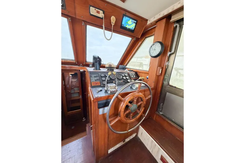 Slide: The Image of 1989 Jefferson Marquessa 52 helm with wooden wheel, gauges, and navigation equipment. - 60
