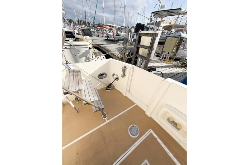 Slide: The Image of 1989 Jefferson Marquessa 52 yacht deck, featuring wooden steps and marina view. - 8