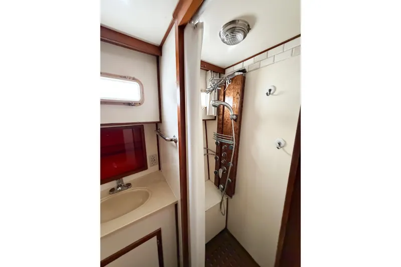 Slide: The Image of 1989 Jefferson Marquessa 52 yacht bathroom with shower and sink, featuring wood accents. - 80