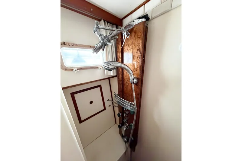 Slide: The Image of Shower area in 1989 Jefferson Marquessa 52 Extended Deckhouse yacht, featuring wood paneling and chrome fixtures. - 83