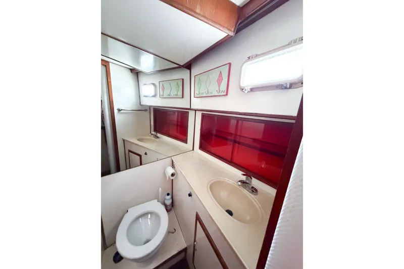 Slide: The Image of Bathroom interior of 1989 Jefferson Marquessa 52 yacht, featuring sink, toilet, and red accents. - 85
