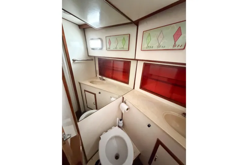 Slide: The Image of Bathroom interior of 1989 Jefferson Marquessa 52 yacht, featuring dual sinks and red accents. - 87
