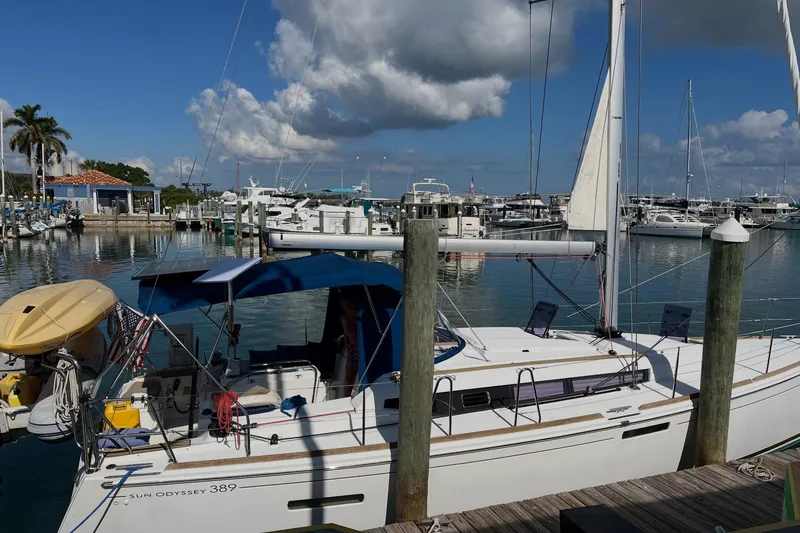 Slide: The Image of 2019 Jeanneau Sun Odyssey 389 sailboat docked at a marina under a blue sky. - 1