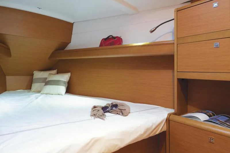 Slide: The Image of Manufacturer Provided Image: Cozy cabin interior of 2019 Jeanneau Sun Odyssey 389 sailboat with bed and storage. - 3