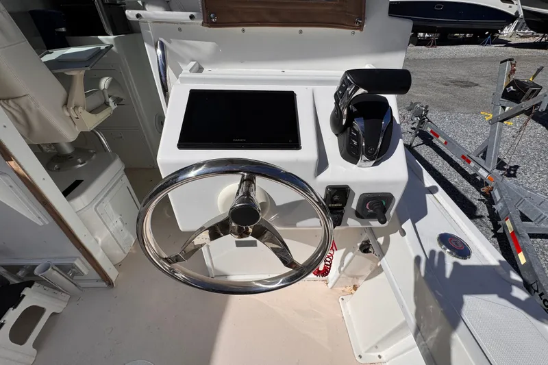 Slide: The Image of 2021 Steiger Craft 25 Chesapeake helm with steering wheel and control panel. - 12