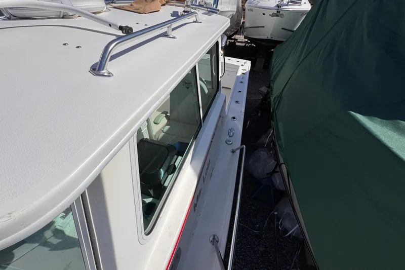 Slide: The Image of 2021 Steiger Craft 25 Chesapeake boat docked, side view with covered vessel nearby. - 29