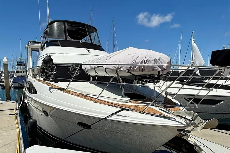 Slide: The Image of New dinghy and outboard perched on rack with lift on bow, shading the tanning lounge while not in use. - 2