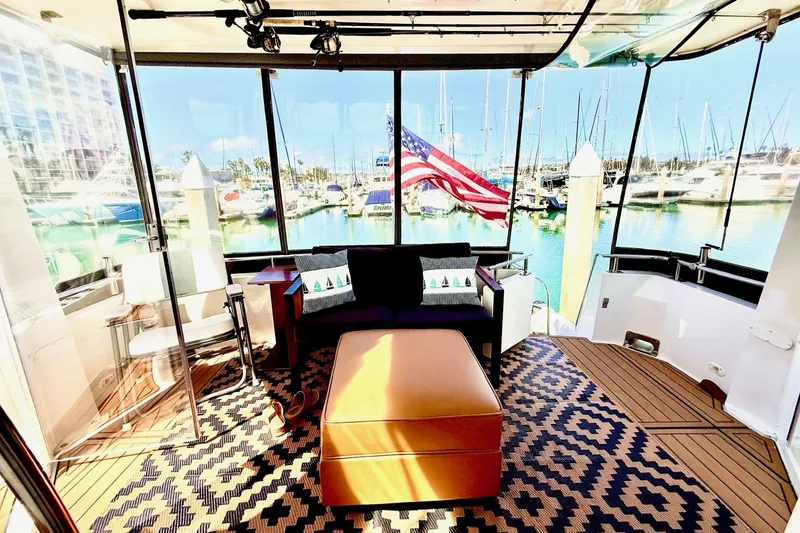 Slide: The Image of Luxurious interior of 2001 Carver 444 Cockpit Motor Yacht with marina view. - 21