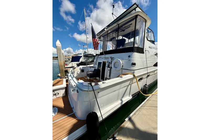 Slide: The Image of 2001 Carver 444 Cockpit Motor Yacht docked, featuring sleek design and American flag. - 3